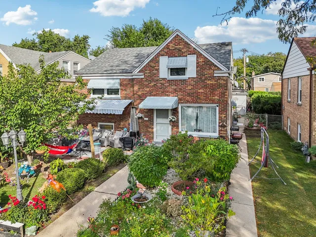 a front view of a house with a yard and potted plants