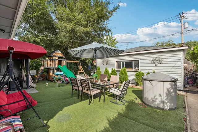 a view of a patio with table and chairs under an umbrella
