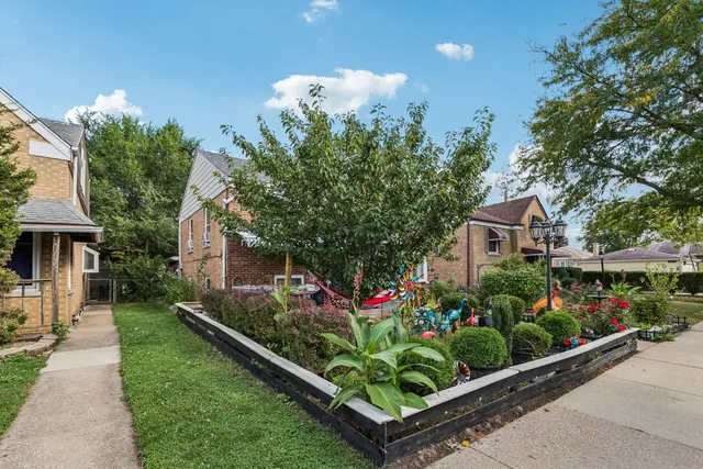 a front view of a house with a yard and potted plants