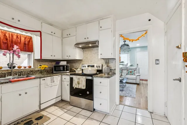 a kitchen with white cabinets and appliances