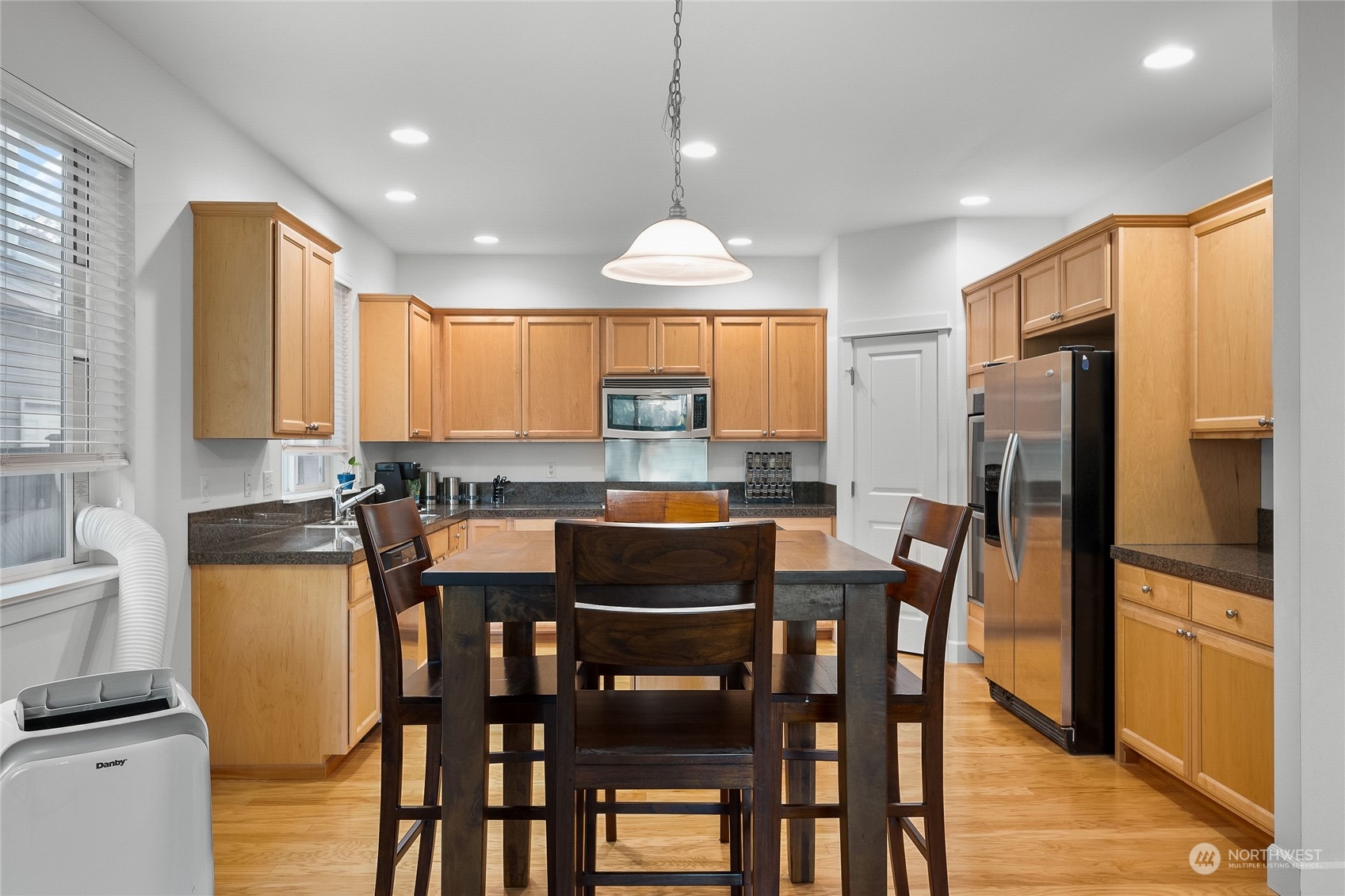 3412 171st Place Southeast Bothell, WA 98012 - Photo 18 of 40 a kitchen with stainless steel appliances granite countertop a dining table chairs refrigerator and a window