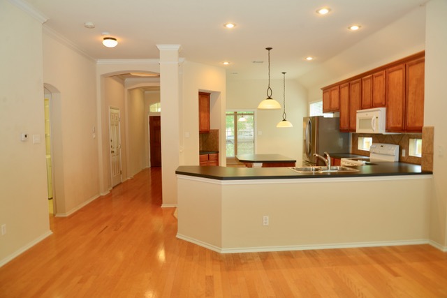 138 Chestnut Court Georgetown, TX 78633 - Photo 16 of 25 Blonde hardwood floors flow seamlessly throughout this open-concept kitchen and living area.