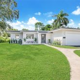 a view of house with backyard and a garden
