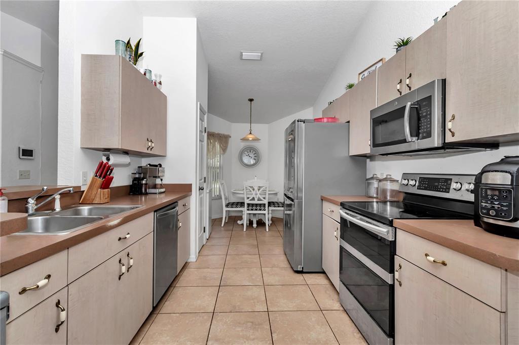 13800 Southwest 33rd Court Road Ocala, FL 34473 - Photo 23 of 42 a kitchen with stainless steel appliances a stove sink microwave and cabinets