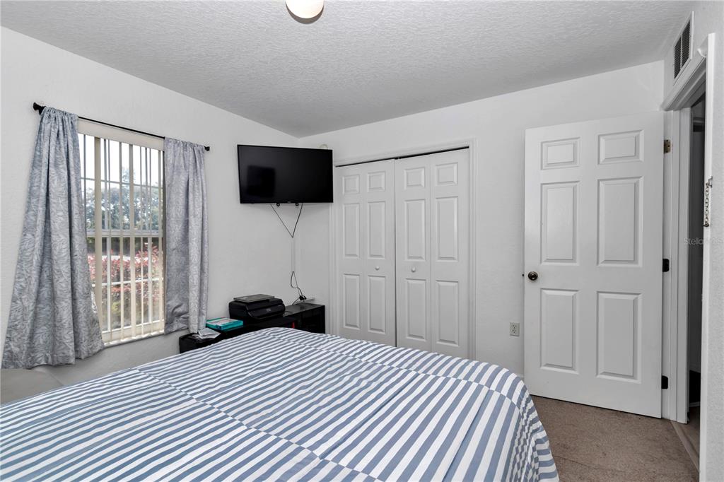 13800 Southwest 33rd Court Road Ocala, FL 34473 - Photo 26 of 42 a bedroom with a bed and a flat screen tv