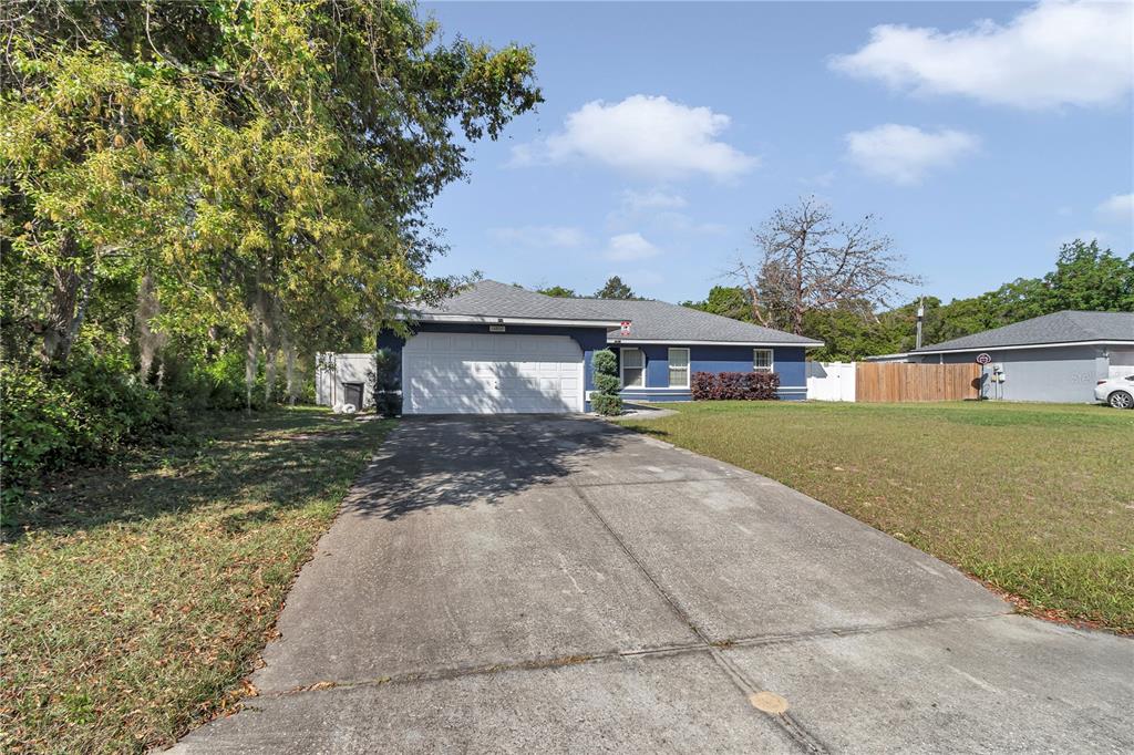 13800 Southwest 33rd Court Road Ocala, FL 34473 - Photo 3 of 42 a front view of a house with a yard and a garage