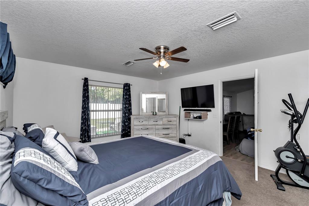 13800 Southwest 33rd Court Road Ocala, FL 34473 - Photo 33 of 42 a bedroom with a bed and a flat screen tv