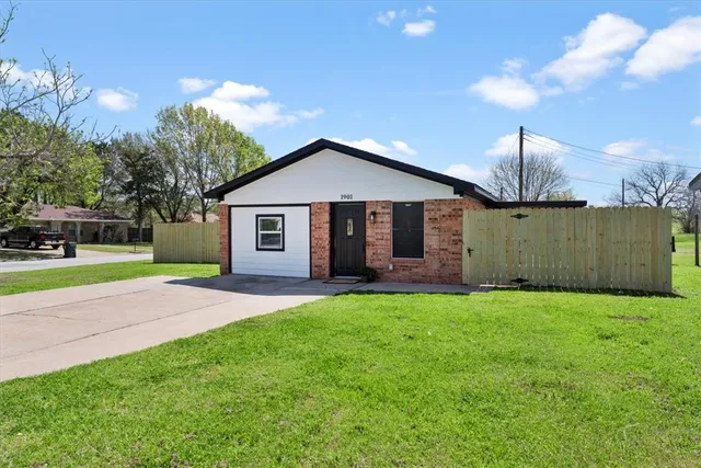 a view of a house with a yard and large tree