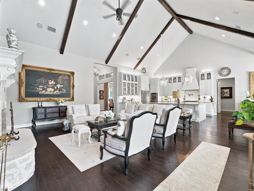 330 Rolling Bnd Road Alvord, TX 76225 - Photo 11 of 36 Vaulted ceiling with exposed wood beams, stone fireplace, wood-finish flooring, recessed lighting, and a kitchen featuring white cabinetry and an island
