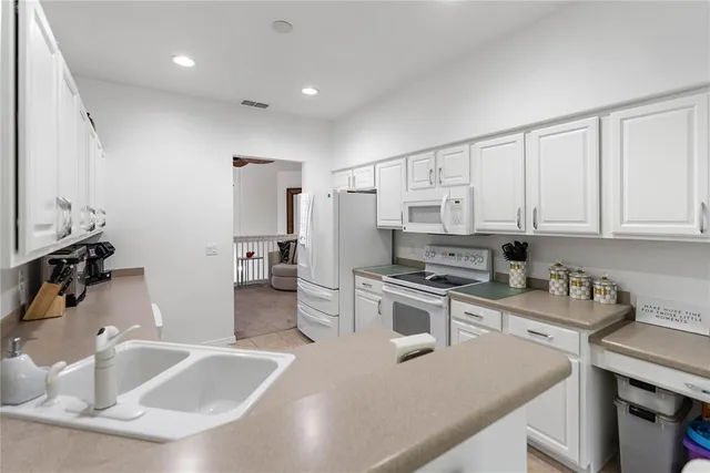 a white kitchen with white cabinets and appliances