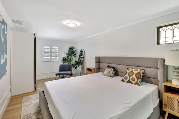 a bedroom with a bed and wooden floor