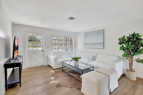 a living room with furniture a potted plant and a window