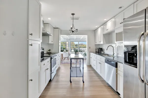 a kitchen with counter top space a sink appliances and cabinets