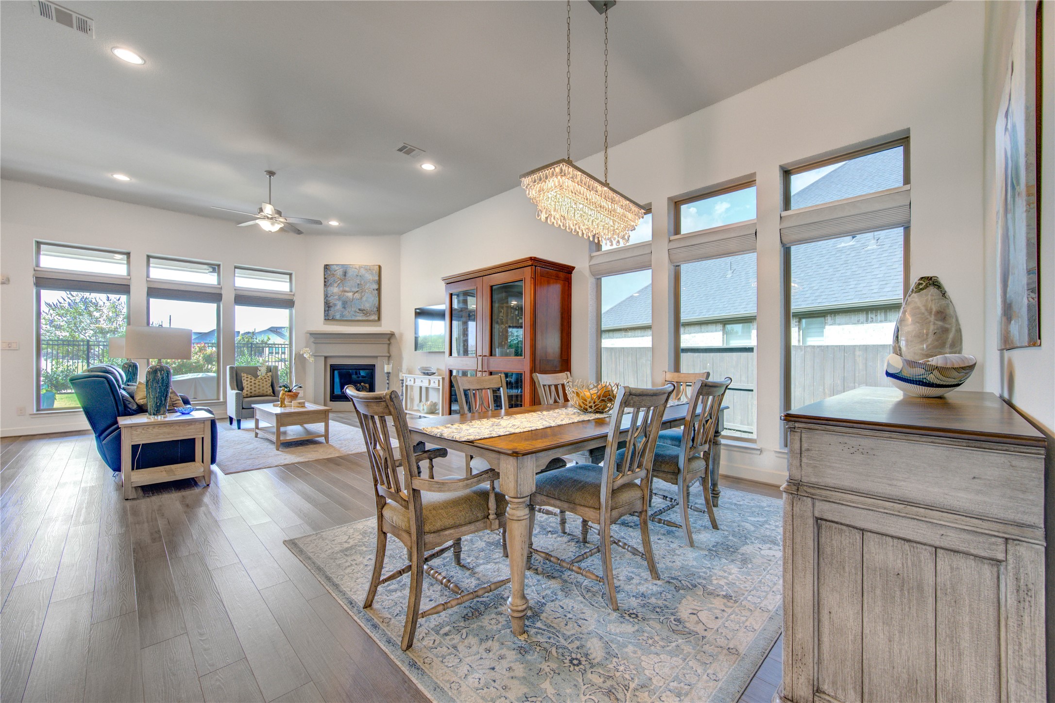 7326 Orangetip Road Katy, TX 77493 - Photo 4 of 43 Elegant Dining Space: The formal dining area is adorned with a modern chandelier and offers ample room for a large dining table, perfect for hosting gatherings while enjoying lake views through the adjacent windows.