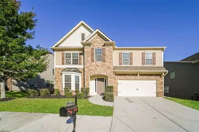 a front view of a house with a yard and garage