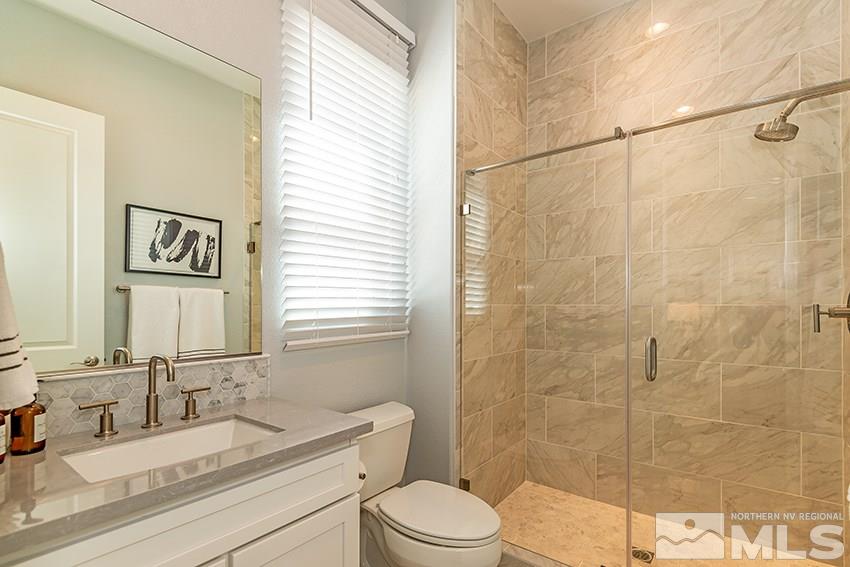 3190 Show Jumper Lane Reno, NV 89521 - Photo 15 of 32 a bathroom with a granite countertop sink toilet a mirror and shower