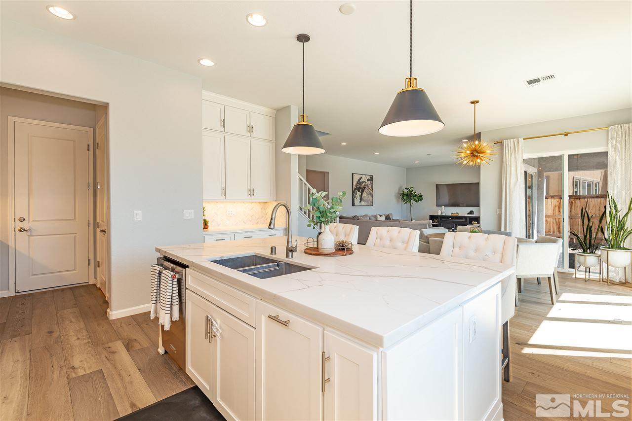 3190 Show Jumper Lane Reno, NV 89521 - Photo 4 of 32 a large kitchen with kitchen island a stove a sink a center island and a wooden floor