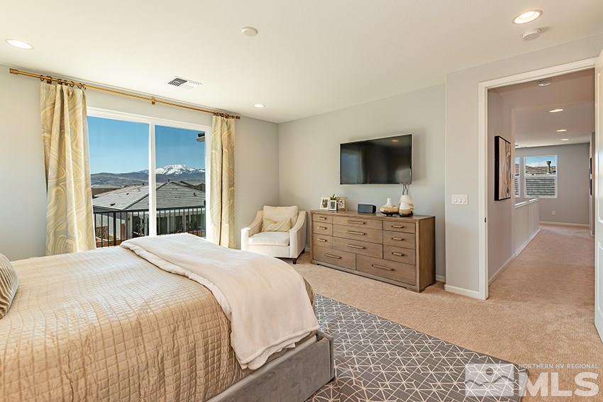 3190 Show Jumper Lane Reno, NV 89521 - Photo 8 of 32 a bedroom with a large bed and a flat tv screen on dresser