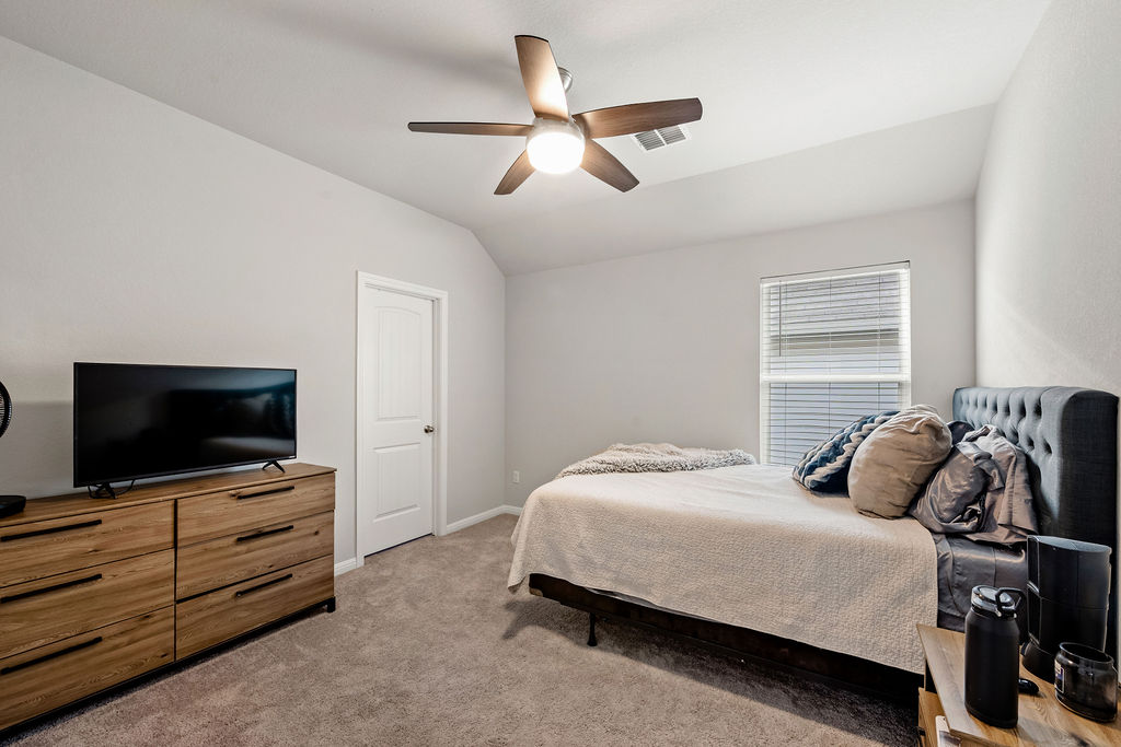2417 Roosevelt Road Leander, TX 78641 - Photo 28 of 40 Bedroom featuring lofted ceiling, light colored carpet, and a ceiling fan