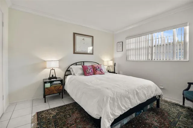 a bedroom with a bed a dresser and next to a window