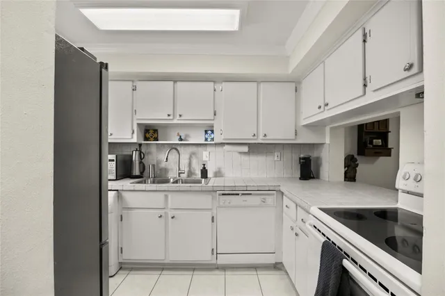 a kitchen with cabinets appliances a sink and a counter top