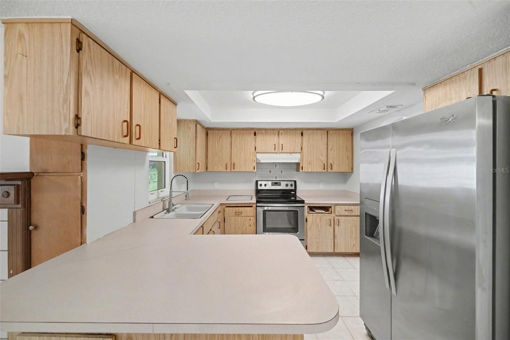 113 Ruskin Avenue Spring Hill, FL 34606 - Photo 10 of 32 a kitchen with a refrigerator and a sink