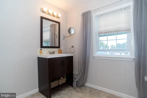 a bathroom with a sink vanity and a mirror
