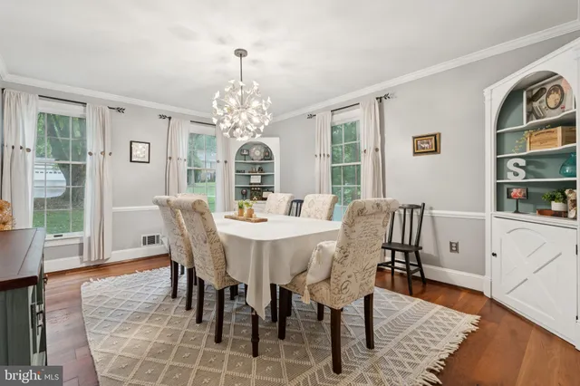 a view of a dining room and livingroom with furniture wooden floor and a window