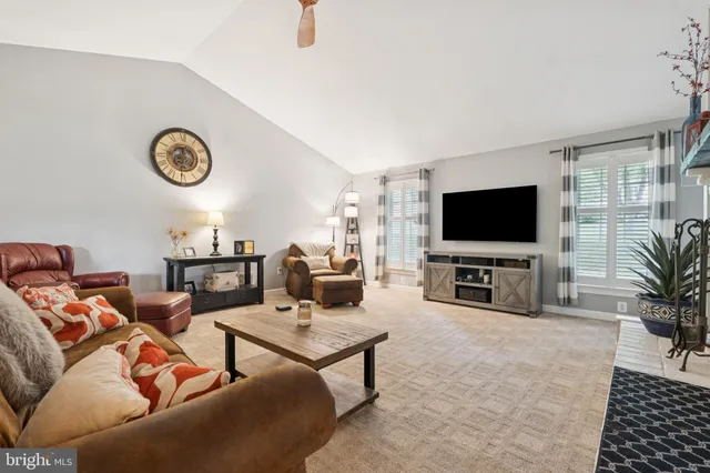a large bedroom with a bed and flat tv screen on the dresser