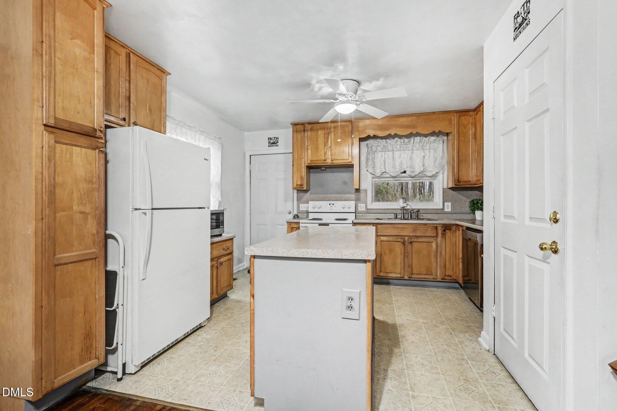 3719 Old Chapel Hill Road Durham, NC 27707 - Photo 10 of 33 a kitchen with kitchen island white cabinets and refrigerator