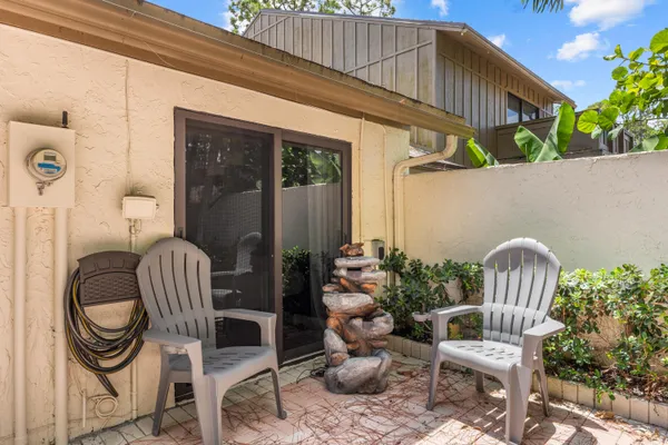 a porch with a bench and some plants