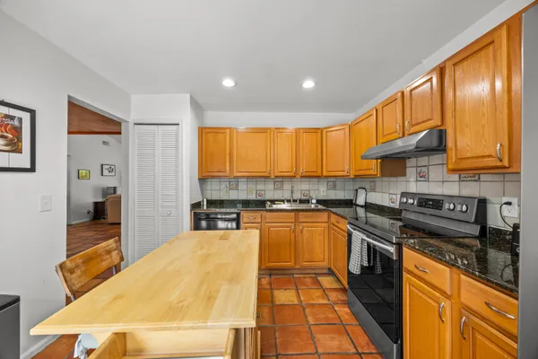 a kitchen with stainless steel appliances granite countertop a sink a stove and cabinets