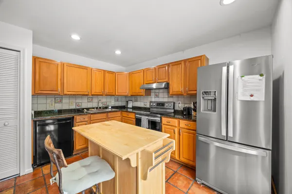 a kitchen with a refrigerator a stove top oven a sink and cabinets