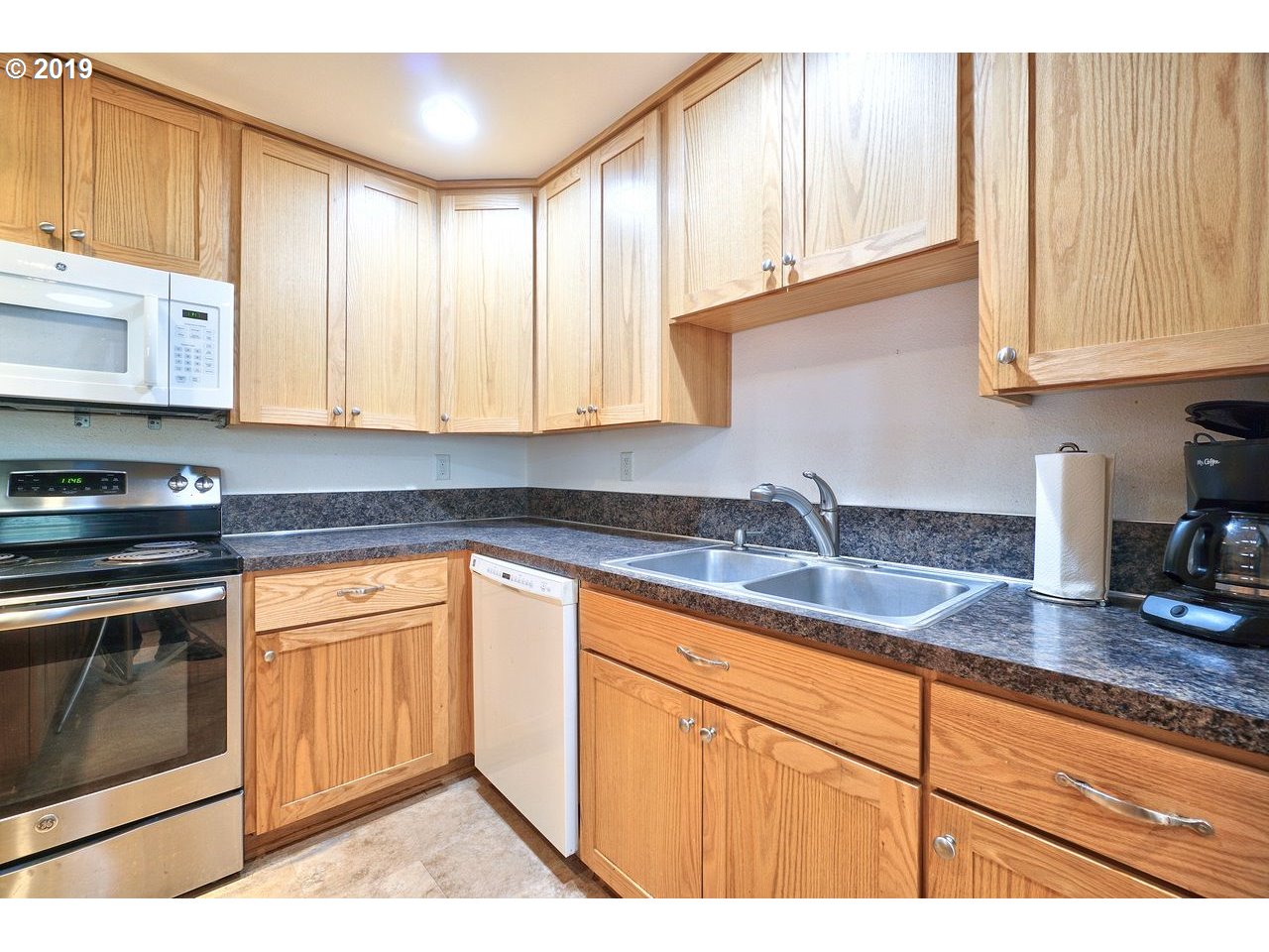 29081 Thistle Hill Road Rainier, OR 97048 - Photo 7 of 32 a kitchen with granite countertop a sink stainless steel appliances white cabinets and a window