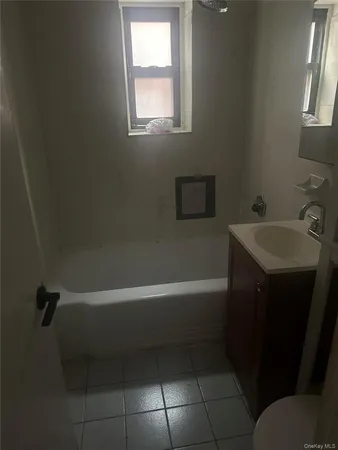 a bathroom with a sink a bathtub and a window