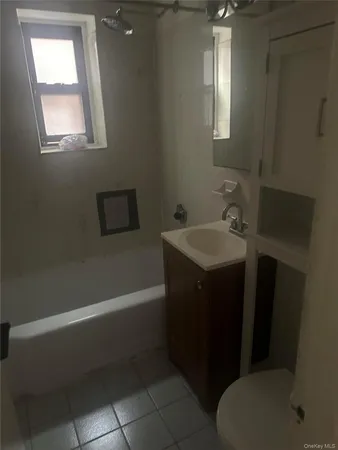 a bathroom with a sink toilet vanity and tub