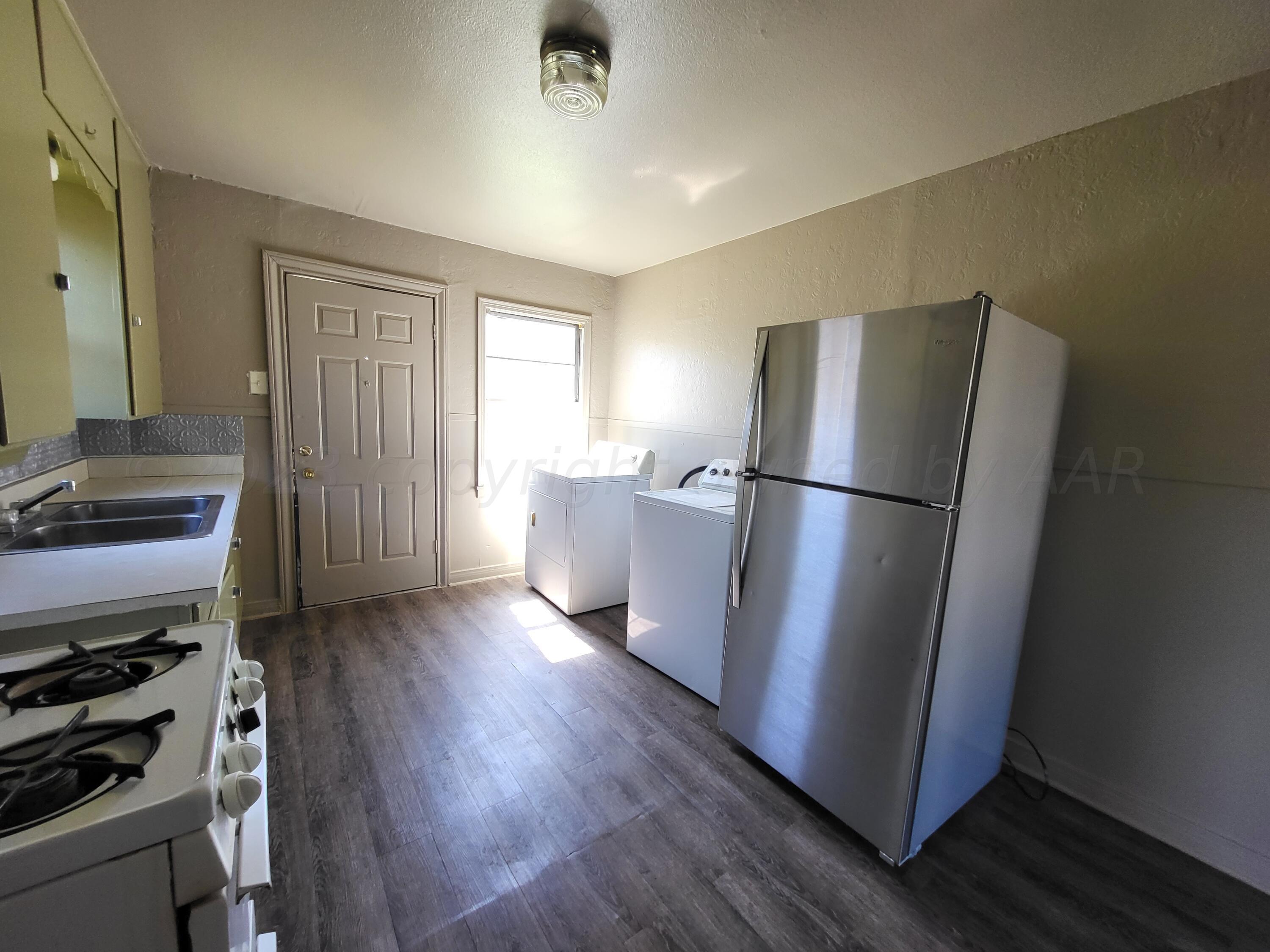 927 South Bryan Street Amarillo, TX 79102 - Photo 8 of 12 a view of a refrigerator in kitchen and wooden floor