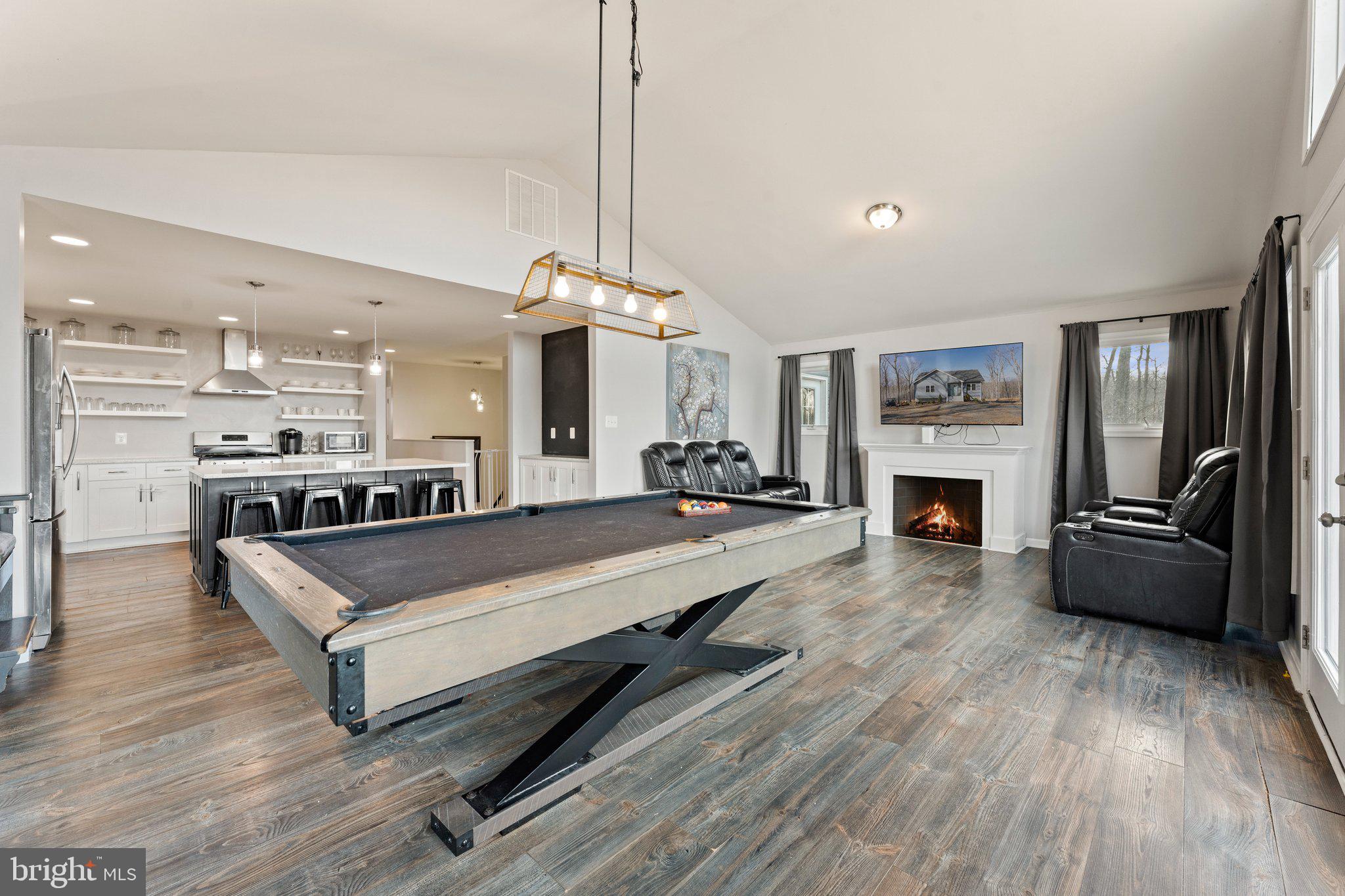 11652 Alum Springs Road Rixeyville, VA 22737 - Photo 30 of 64 a large living room with stainless steel appliances kitchen island furniture and a fireplace