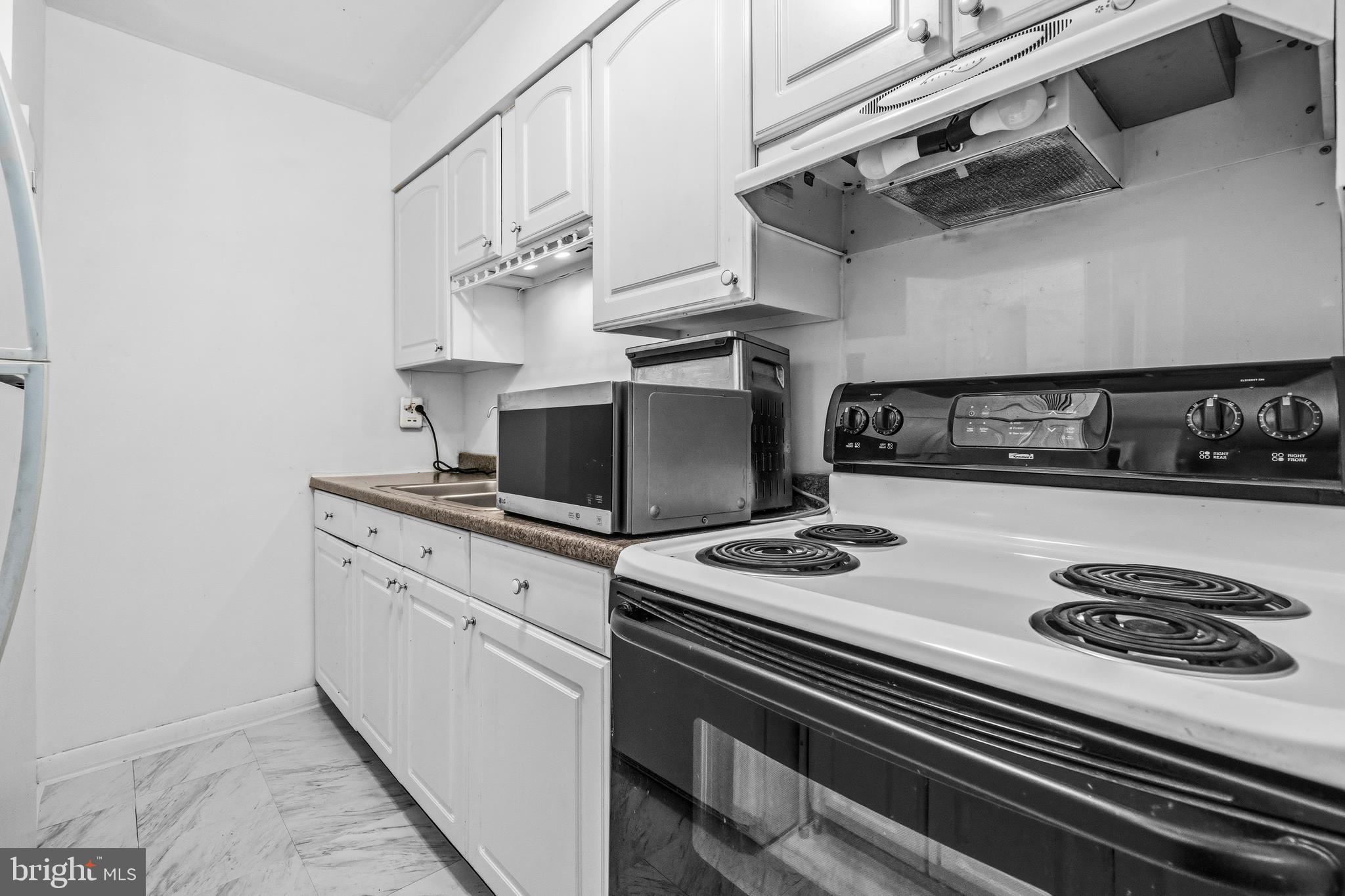 5913 Prince James Drive, Unit J Springfield, VA 22152 - Photo 9 of 33 a kitchen with a stove and a microwave