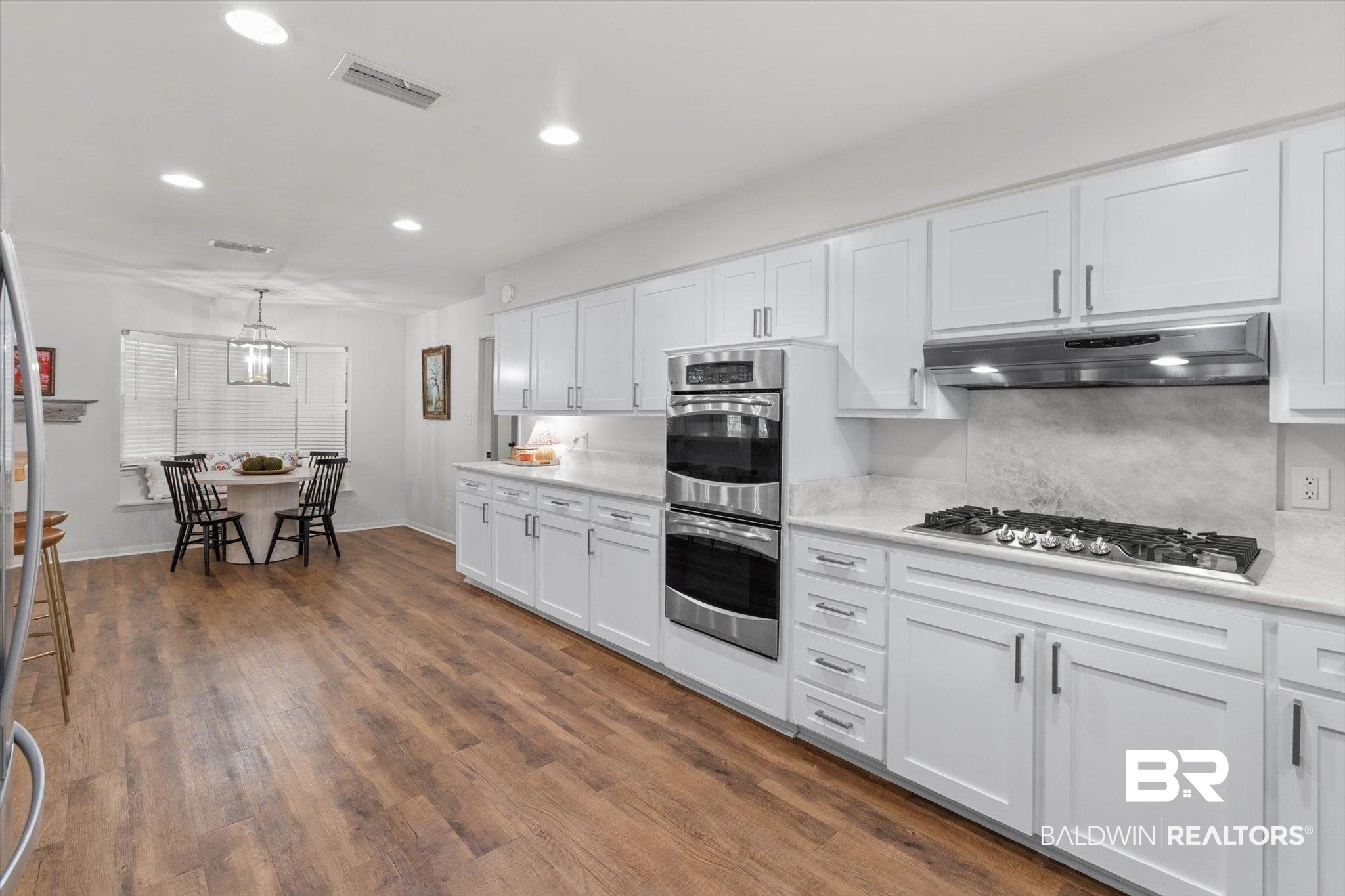254 Woodlands Avenue Mobile, AL 36607 - Photo 9 of 50 Kitchen featuring white cabinetry, appliances with stainless steel finishes, recessed lighting, hanging light fixtures, and dark wood finished floors