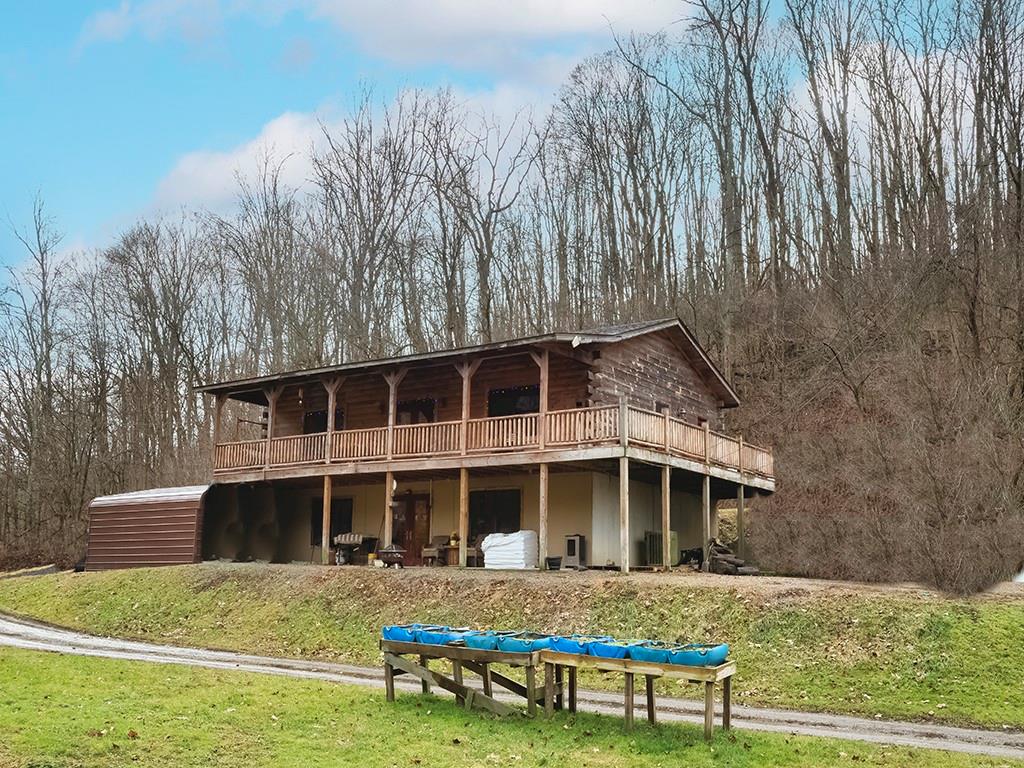 a view of a house with backyard and trees in the background