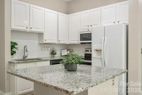 a kitchen with stainless steel appliances granite countertop a sink a stove and a granite counter tops