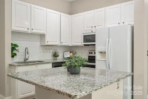 a kitchen with stainless steel appliances granite countertop a sink a stove and a granite counter tops