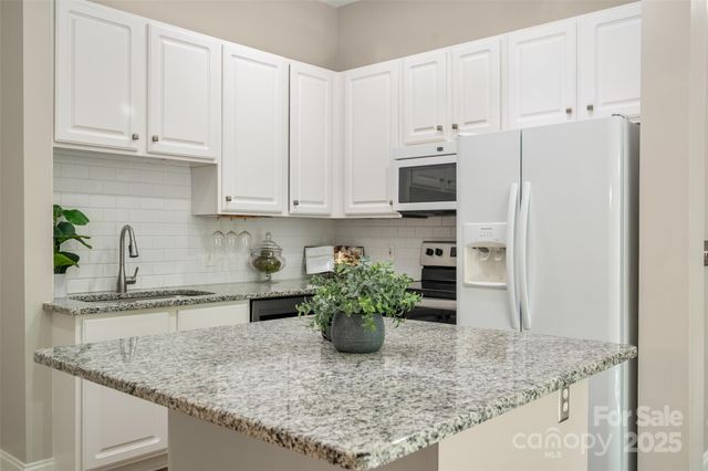 a kitchen with stainless steel appliances granite countertop a sink a stove and a granite counter tops
