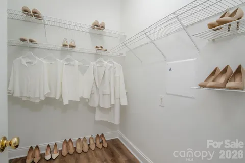 a view of walk in closet with clothes and shoes