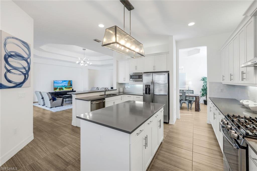4549 Azalea Drive Naples, FL 34119 - Photo 12 of 49 a kitchen with stainless steel appliances granite countertop a sink a stove and a wooden floors