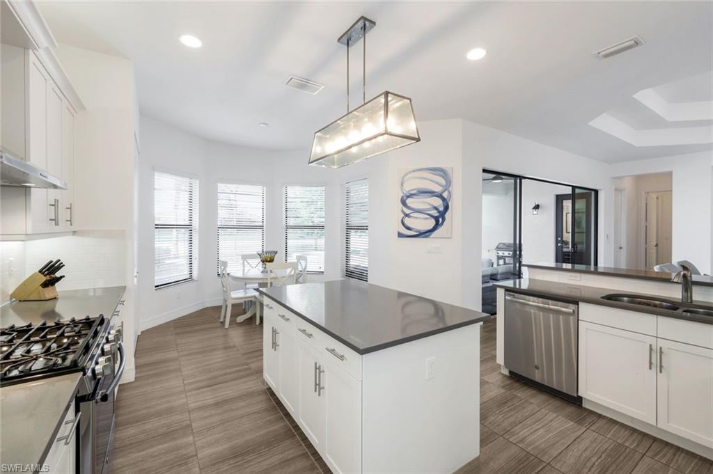 4549 Azalea Drive Naples, FL 34119 - Photo 16 of 49 a very nice looking kitchen with granite countertop a stove and a large window