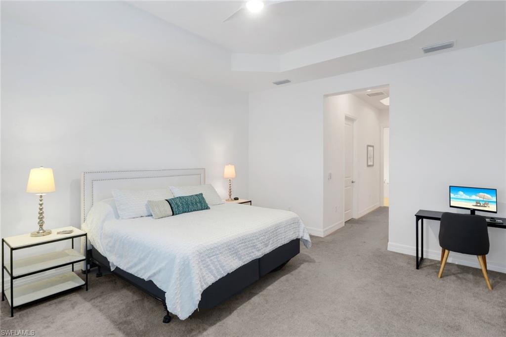 4549 Azalea Drive Naples, FL 34119 - Photo 23 of 49 a bedroom with a bed and a lamp on table