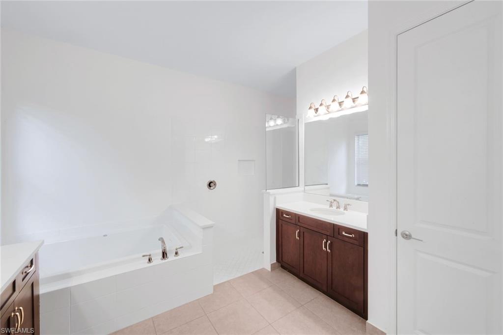 4549 Azalea Drive Naples, FL 34119 - Photo 26 of 49 a spacious bathroom with a bathtub sink and mirror