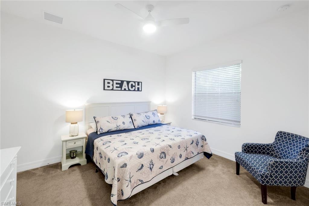 4549 Azalea Drive Naples, FL 34119 - Photo 29 of 49 a bedroom with a bed and a couch